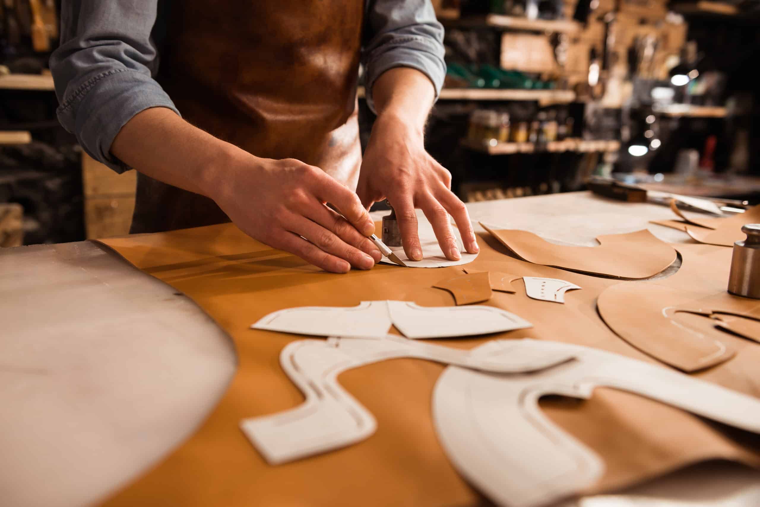 close up shoemaker measuring cutting leather scaled