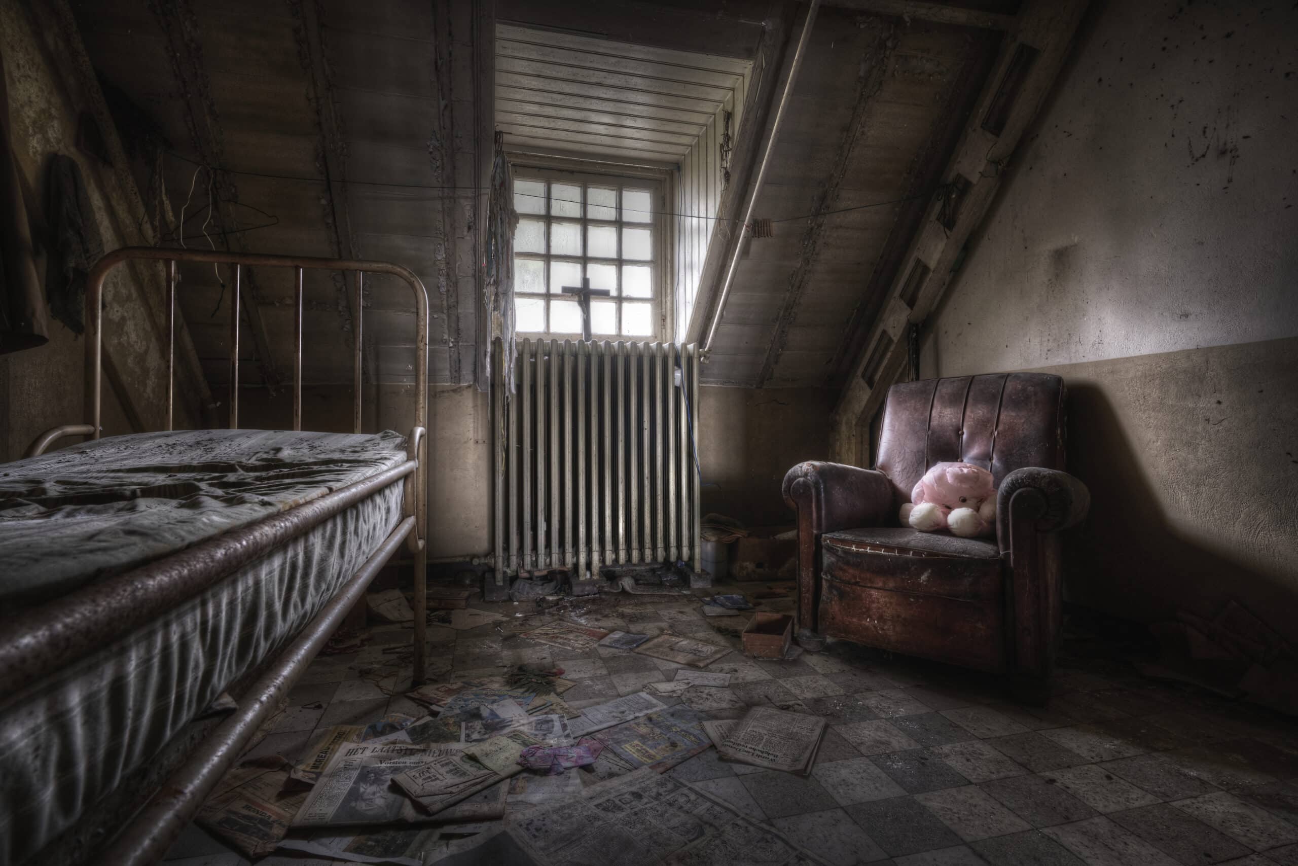 Lit en fer ancien à la peinture écaillée et rouillée, dans une chambre laissée à l'abandon