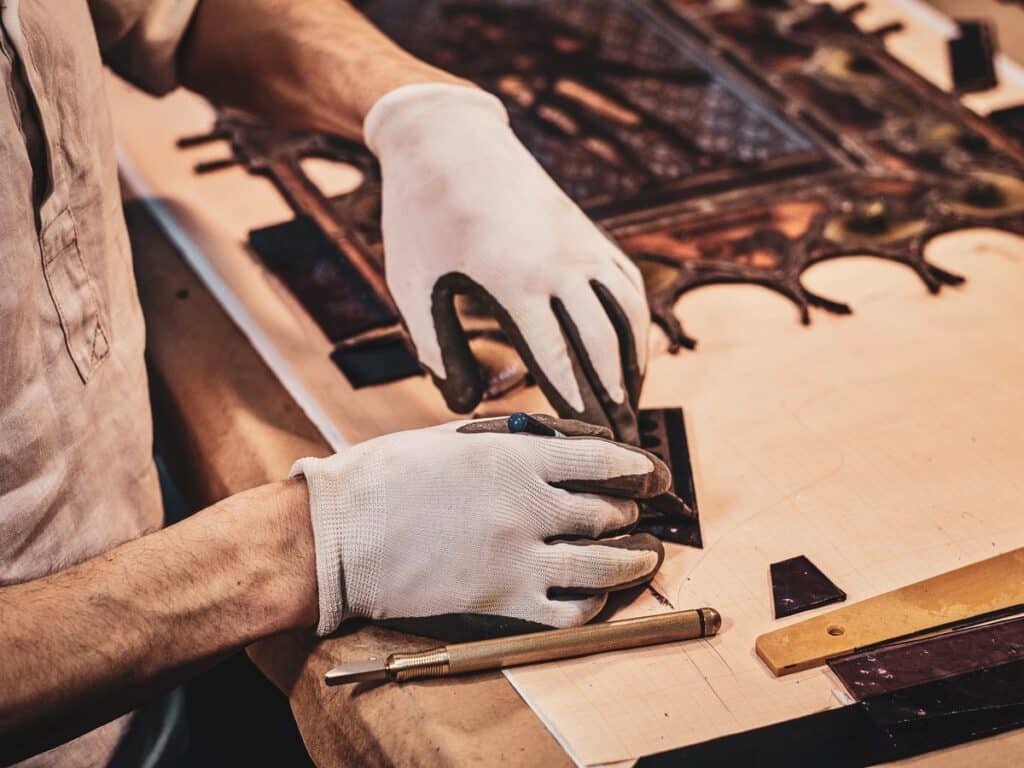 Restauration d’un vitrail ancien, gants aux mains — guide Devenir vitrailliste