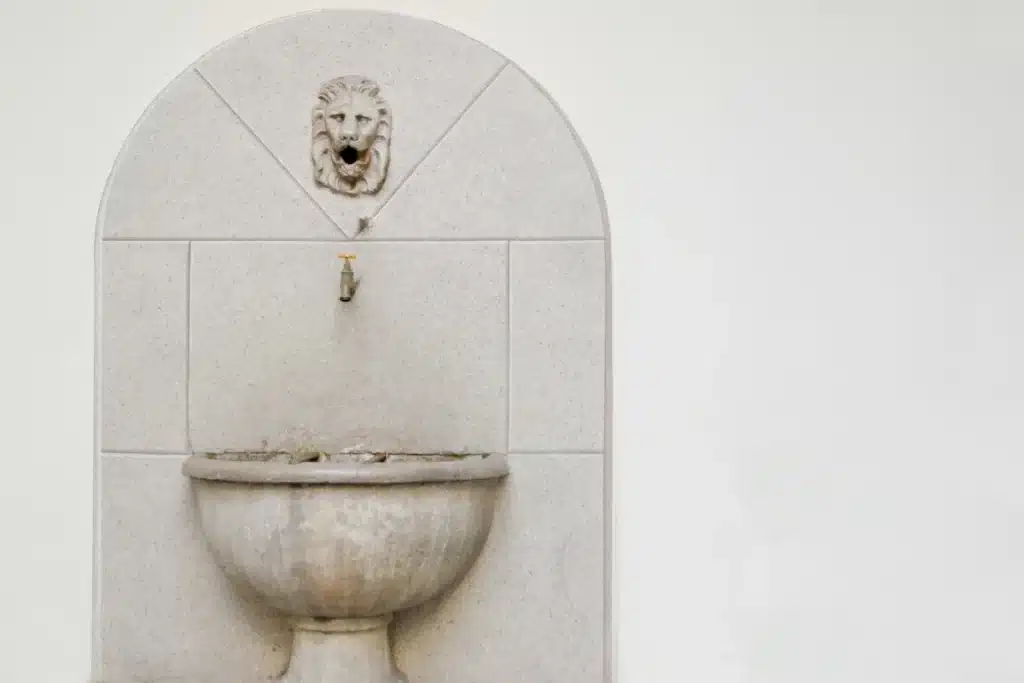 Fontaine ancienne en pierre avec une tête de lion